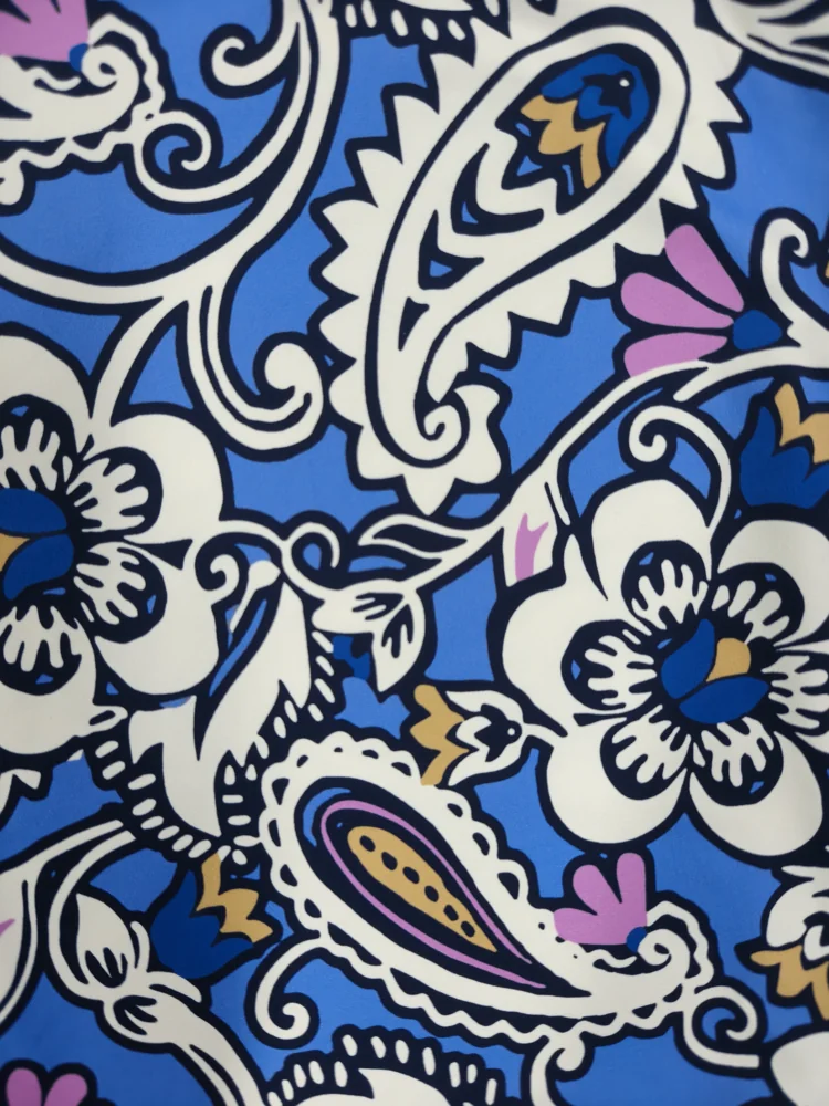 Close-up of swimwear fabric with an all-over blue paisley and floral print