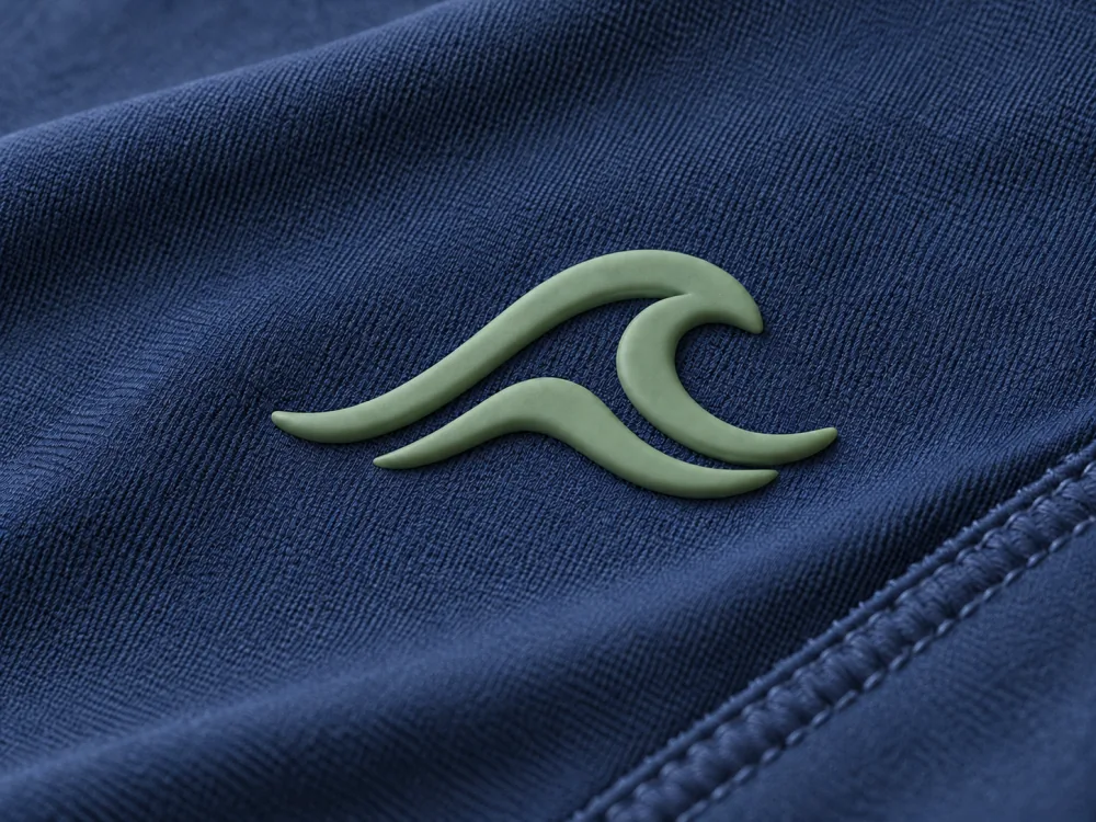 AI-generated illustration of raised sage-green silicone wave artwork on navy swimwear fabric
