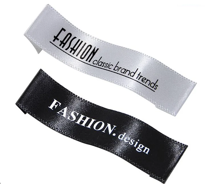 Two custom garment labels in white and black printed with sample brand text